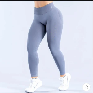 Grå höga leggings från DFYNE - Snygga grå leggings från DFYNE med tight passform. De är tillverkade i ett stretchigt syntetmaterial som sitter skönt och formar kroppen. Perfekta för gymmet eller andra träningspass. Diskret logga på linningen och stilren design. Nypris runt 700 kr