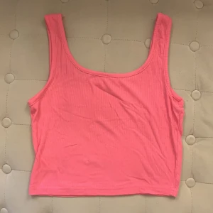 Rosa ribbad linnetopp - Rosa linnetopp med ribbad struktur och croppad passform. Toppen är med breda axelband. Använt 3 gånger max. Söt o skönt material, storlek S men passar även Xs💗