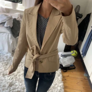 Trenchcoat  - Kavaj/trenchcoat jätte fin, ena knappen hänger löst men de är inget man tänker på, xxs