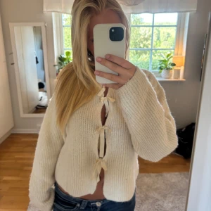 Vit stickad kofta med knyt - Superfin vit stickad kofta med tre söta knyt framtill💕Tröjan är knappt använd💕Tröjan är i barnstorlek med sitter som s💕