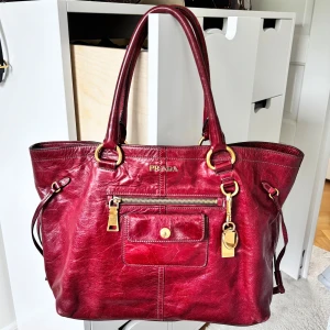 vintage prada väska - säljer min vintage prada väska som jag fick av mamma , köptes i harrods london! färgen är mindre skrikig irl, för att vara mer än 10 år gammal är den i jätte bra skick! såklart finns de tecken av användning som alla vintage väskor,  liknande säljs på hemsidor för runt 5-9tusen. Självklart äkta , vet inte exakta måtten men skulle gissa på 35cm ish