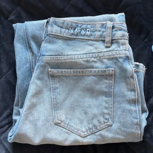 Ljusblå wide jeans från NA-KD, stl 34 - Säljer ett par ljusblå jeans från NA-KD i storlek 34. Modellen har hög midja och raka, breda ben. Nypris 599kr, endast använda fåtal gånger.