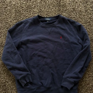 Mörkblå sweatshirt från Polo Ralph Lauren - Säljer en mörkblå sweatshirt från Polo Ralph Lauren med klassisk rund hals och långärmad passform. 