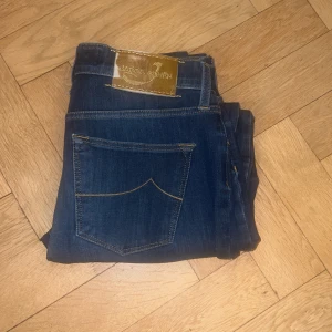 Mörkblå jeans från Jacob Cohen - Snygga mörkblå jeans från Jacob Cohen med klassisk femficksdesign och kontrastsömmar. Jeansen har en stilren läderpatch med logga bak i midjan och är tillverkade i mjukt denimtyg som sitter skönt hela dagen.