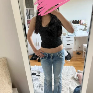 G-Star ljusblå bootcut jeans - Säljer ett par ljusblå jeans från G-Star med bootcut passform och låg midja. Jeansen har coola detaljer som dragkedja på bakfickan, dubbla knappar i midjan och snygga sömmar. Perfekt för dig som gillar street och vill ha något unikt i garderoben. W25 L32