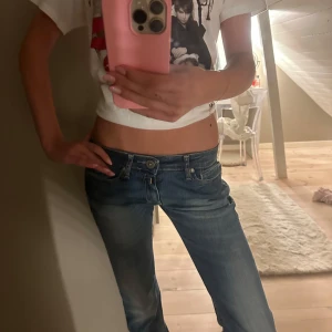 Replay jeans lågmidjade blå bootcut - Säljer ett par snygga Replay jeans i klassisk blå tvätt med coola slitningar och broderade detaljer på bakfickorna. Modellen är lågmidjad med bootcut.Jeansen har dragkedja och knapp framtill. Waist 25, Lenght 32. 💞 #snygga jeans #lowboot #replay