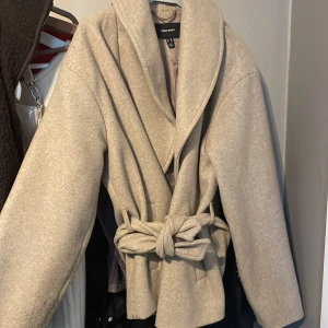 Beige omlott kappa från Vero Moda - Snygg beige kappa från Vero Moda, använd 1 gång av mig men har fått den av min syster. den är lite knottrig på vissa ställen men de kan jag försöka få bort :) jättefin 