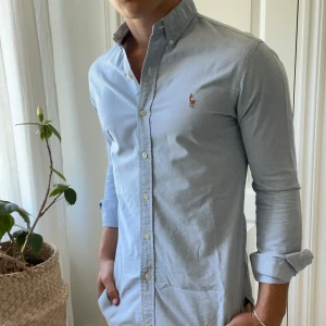 Ralph Lauren hel blå skjorta  - Ralph Lauren skjorta i storlek S slim fit, modellen är 180,75 kg kom med frågor! Kom med frågor 🫶 inga större defekter men en extremt minimalt defekt vid ärmen då skjortan har använts tidigare, kolla på bilden så fattar ni! Kommer knappt se det. 