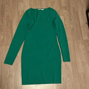Grön långärmad klänning från NA-KD - Snygg grön kortare klänning från NA-KD i storlek M. Modellen är kort med långa armar samt den sitter tightare på än bilden visar🩷