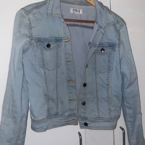 Ljusblå jeansjacka från Even&Odd - Snygg ljusblå jeansjacka från Even&Odd i klassisk modell med knappar framtill och två bröstfickor. Jackan har lång ärm och är tillverkad i slitstarkt denim-material. 