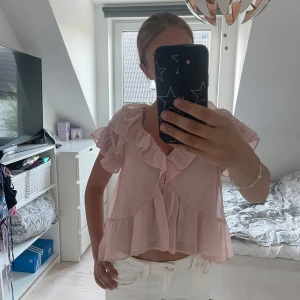 Ljusrosa volangblus från Nelly - Supersöt ljusrosa blus från Nelly med volanger längs halsringningen, ärmarna och nederkanten. Knappast använd och i nyskick💘💘