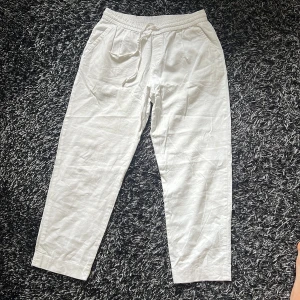 PERFEKTA Vita linnebyxor - Trött på vita byxor där fickorna syns? Vill du ha världens snyggaste linnebyxor i sommar? Är du runt 170-180 och har lite längre ben. Då är dessa perfekta! Snygga vita linnebyxor med elastisk midja och snörning framtill. Byxorna har raka ben, sidofickor och bakfickor. Perfekta för en chill och avslappnad stil under varmare dagar. Storlek M