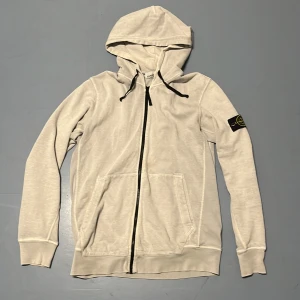 Stone Island Zip Hoodie - Tja säljer en Stone Island Hoodie i färgen Grå och i storlek XXL men sitter mer som L passar 185-190 cm ungefär. Nypris 4000 KR mitt pris 799 KR. Finns en fläck(5e bilden). Skriv vid frågor eller funderingar.