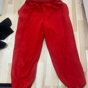 Röda mjukisbyxor från H&M XS - Röda mjukisbyxor från H&M i storlek XS. Byxorna har resår i midjan och är gjorda i en mjuk bomulls- och polyestermix. Perfekta för chill dagar eller när du vill vara extra bekväm. Klassisk loose fit med enkel design.