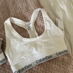 calvin klein toppar - säljer två st calvin klein toppar som aldrig är använda. en grå och en vit. de kan användas i vardagen, till träning och när man sover
