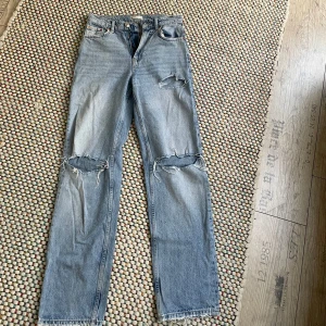 Gina tricot jeans  -  jeans med raka ben och snygga slitningar över knäna och bakfickorna. Klassisk femficksmodell i 100% bomull med hög midja och vintagekänsla. Perfekta för en avslappnad streetstil.