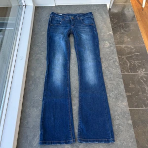 Blå bootcut jeans - Så snygga bootut jeans. Strechiga. Innerbenslängd: ca 80-81 cm Midjemått: ca 38 cm midjehöjd: ca 19 cm 