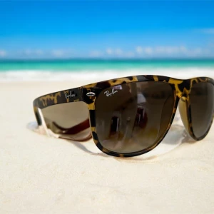 Ray-Ban solglasögon  - (Kom privat innan köp)Snygga Ray-Ban solglasögon med klassisk wayfarer-form och leopardmönstrad båge i bruna och gula toner. Glasen är mörka och ger ett coolt intryck. Perfekta för att sticka ut på stranden eller i stan. Modell RB 4147, tillverkade i Italien.