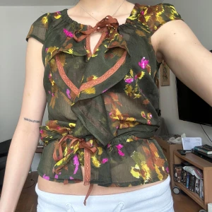 Mönstrad blus med volanger och knytning - Fint skick! Strl M men går att justera passform och längd med knytning🌟