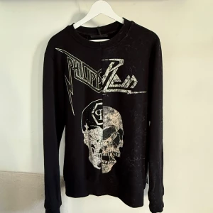 Philip Plein tröja - Säljer denna åt min kille då han inte använder den mer! Sparsamt använd och ser ut som ny, alla stenar osv sitter kvar! Finns äkthetsbevis, qr kod samt äkthetsnummer som jag skickar bild på vid intresse! 