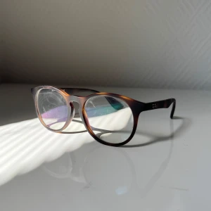Ray Ban Slipad glasögon - Säljer ett par snygga Ray-Ban slipad glasögon i snygg färg brun  Tyvärr så vet jag inte hur slipad dom är, jag som ser bra nog skulle säga det är inget skillnad efter dom sitter på, jag ser lika tydligt som annars, den är väldigt bra som ny bara lite smuts på kanterna   Jag vet riktigt inte vad det är för material men något mjukt känns som mjuk plast  Priset kan diskuteras och kan köpas med andra glasögon i min profil för bra pris