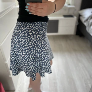 Somrig kjol - Supersöt blå kortkjol från lager 157 med vitt blommönster och elastisk midja. Kjolen har en lätt utställd form och är perfekt för dig som gillar en avslappnad och somrig stil. Tunn och skön, passar perfekt till sneakers eller sandaler. Använd fåtal gånger och i jättefint skick. Stolek XS/S