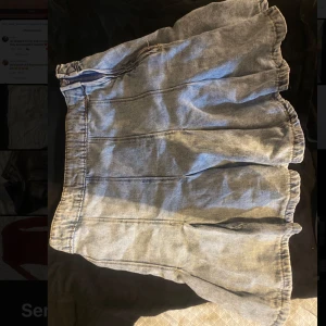 Ljusblå jeanskjol med volang - Säljer en ljusblå kort jeanskjol med dragkedja i sidan. Kjolen har en lätt utställd form och volang.