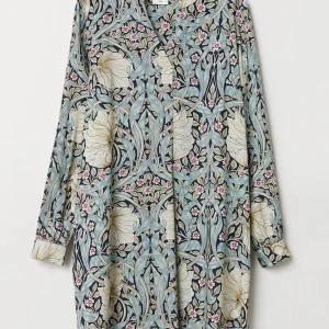 Blommig Tunika blus från Morris & Co x H&M - En blommig Tunika blus från Morris & Co x H&M med vackert mönster i beige, blått och rosa.  Tunikablus lång ärm, v-ringning och ett löst fall. Perfekt för dig som gillar unika prints och bekväma plagg.