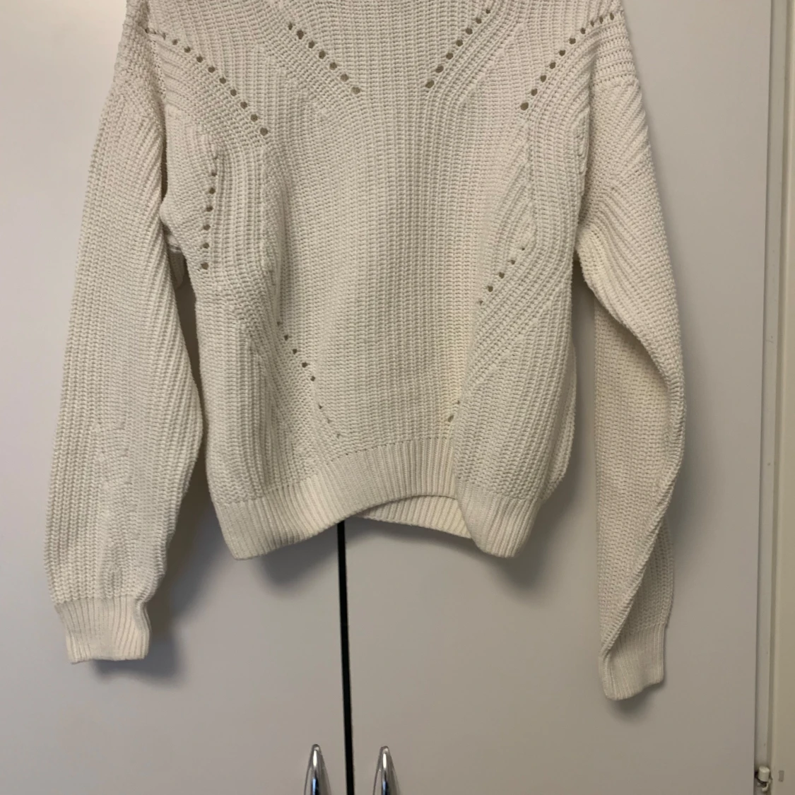 Vit stickad tröja med hålmönster