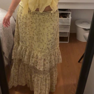 Gul långkjol - Ljusgul långkjol med blommor och volanger