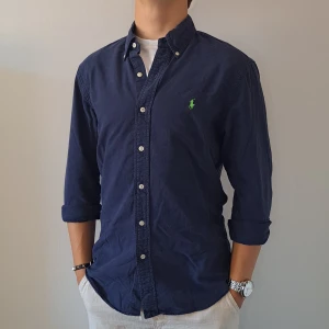 Marinblå Ralph Lauren Skjorta - Stl M, Slim Fit - Hej säljer en fin Ralph Lauren skjorta I färgen Marinblå, Perfekt till sommaren! 🏖🏝 | Skick: 9/10 | Stl: M, Slim fit | Han på bilden är 172cm | Fraktar spårbart med Instabox eller Postnord | Mvh Galgen 🤗