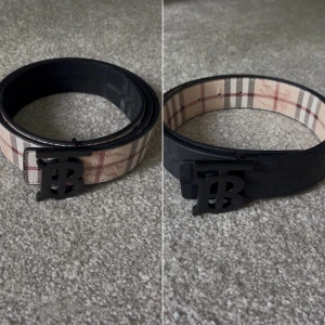 Burberry vändbart bälte med monogram - Säljer ett vändbart Burberry-bälte i skinn med klassiskt rutig design på ena sidan och svart präglad logga på andra. Skick 8/10, 95 cm