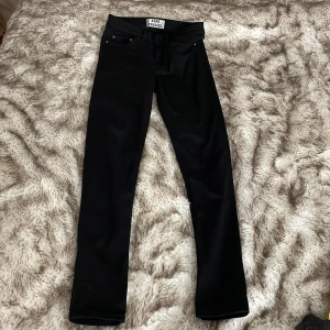 Acne Studios svarta skinny jeans 26/32 - Svarta skinny jeans från Acne Studios, modell Skin 5 Lacey Black. Klassisk femficksdesign, dragkedjegylf och smal passform. Tillverkade i bomull med stretch för en bekväm känsla. Perfekta till sneakers eller boots.