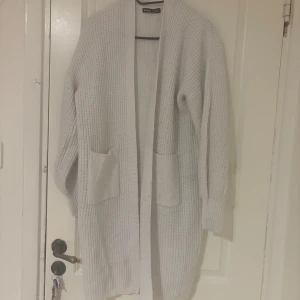 Ljus stickad lång kofta från SHEIN - Mysig ljus stickad kofta från SHEIN i storlek S. Koftan är lång, har två stora fickor framtill 🌸