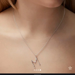 Silverhalsband med M-bokstav - Stilrent halsband i silverfärg med en tunn kedja och ett hänge format som bokstaven N! Maria Nilsdotter💓Jättebra skick!