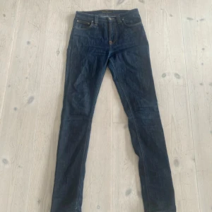 Mörkblå jeans från Nudie Jeans - Tjena! Säljer nu dessa mörkblå nudie jeansen för endast 399kr! Nypris ligger på ungefär 2000kr🤯. Mycket bra skick och använda ett par gånger. Det står ingen storlek i men jag har storlek w27 och dom passar mig perfekt! Jeansens passform är slim. Priset går att diskutera! Var inte rädd för frågor!😁