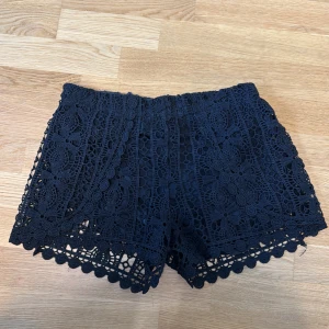 Svarta spetsiga shorts med blommönster - Supersnygga svarta shorts med blommig spets och fina detaljer. De är lågmidjade och har som undershorts❣️Storlek L men passar S/M