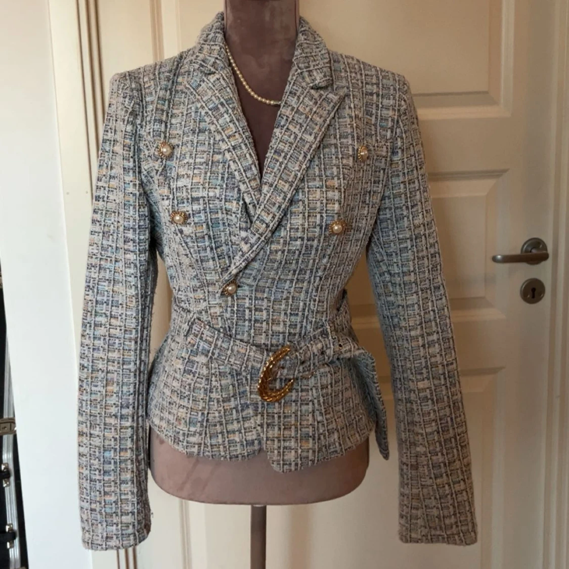 Rutig kavaj med bälte och pärlknappar