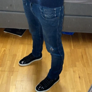 Replay anbass jeans - Tjena säljer dessa feta mörkblåa replay anbass jeans i storlek 28/32 med hemma gjorda slitningar i modellen slim fit. Skicket är 8,5/10 de har inga defekter eller skador förutom slitningarna. Jag på bilden är 176 och väger 62kg och de sitter ganska bra. Tveka inte att höra av dig om du har några frågor!