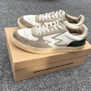 Beige och vita sneakers från MOA Concept - Snygga sneakers från MOA Concept köpta på NK, göteborg. Nypris 2500 kr. Storleken är 43, men är stor i storleken. Passar därför 44 perfekt! Pris kan diskuteras, hör av dig vid minsta fråga!