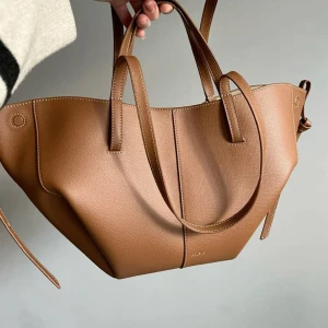 Polène brun axelväska i skinn - Äkta Polène Cyme i färgen Camel. Stilren och rymlig väska i kalvskinn.  👜 Mått: 27 x 20 x 15.5 cm ✔️ Fint skick ✔️ Inköpt från Polène Paris