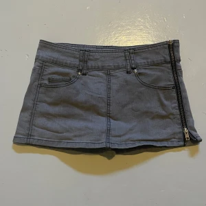 grå kort kjol med dragkedja - skitsnygg kjol!! den är vintage och jag skulle verkligen velat ha kvar den men den passa inte mig bra💔💔kjolen är storlek 34/xs som jag tycker stämmer, fråga gärna om mått!🫶kjolen är väldigt enkel men unik med dragkedjan. väldigt bra skick, knappast använd!