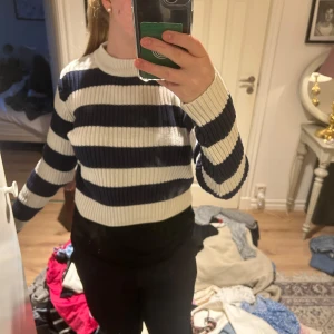 Randig stickad tröja  - Säljer en ribbstickad tröja från 157 i storlek S. Tröjan har breda marinblå och vita ränder, rund halsringning och långa ärmar. Perfekt för dig som gillar klassiska och bekväma plagg med lite sportig känsla.