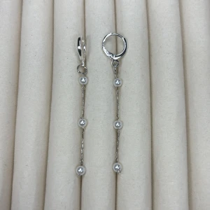 Silverfärgade örhängen med pärlor - Säljer ett par eleganta, långa örhängen i silverfärg med fyra små vita pärlor på varje hänge. Perfekta för dig som gillar stilrena och trendiga smycken med en touch av klass.