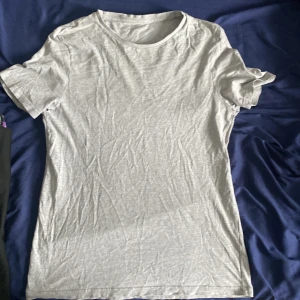 Ljusgrå t-shirt från Pier One - En basic ljusgrå t-shirt från Pier One i mjuk bomull. T-shirten har rund halsringning och korta ärmar, perfekt för en enkel och stilren look.