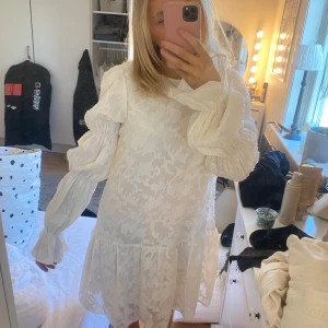 Vit klänning med volang från Gina Tricot - Superfin vit klänning från Gina Tricot i storlek 34. Klänningen har långa puffärmar, volang nertill och öppen rygg med knyttband. Perfekt för sommarens tillfällen! Har aldrig användt! jag hitta en Annan klänning så säljer denna. Köpte den för 500 kr så senfärdig säljer jag för 400kr