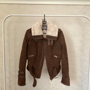 Brun mockajacka från Jofama by Kenza modell 7 - Säljer en brun mockajacka från Jofama by Kenza. Är inte använd av mig men köpte den i redan begagnat skick. Är i fint skick, men har en liten brun fläck på insidan av det vita fodret. Syns dock inte när jackan sitter på :) Passar mig som vanligtvis har storlek S och 34 med en tjocktröja under. Nypris 2500:-