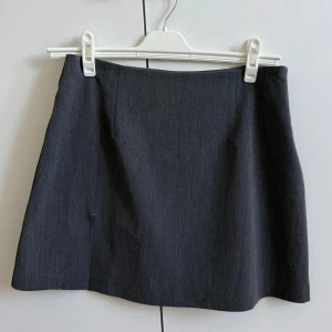 Kjol, Djerf Avenue - Grå kjol med en slits, från Djerf Avenue. Kjolen har en enkel och klassisk design som passar perfekt till många olika outfits💞