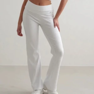 Vita ribbade yogabyxor från aimin  - Säljer ett par vita ribbade yogabyxor från aimin med bred midjeresår. Byxorna har en rak passform och är tillverkade i mjukt, stretchigt material som sitter skönt på kroppen. Perfekta för en avslappnad look.