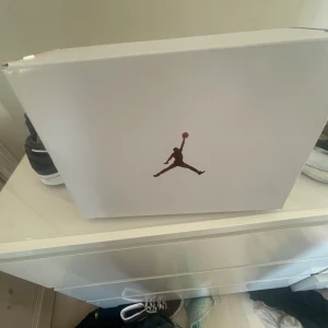 Nike Air Jordans Low grå/vit - Säljer ett par Nike Air Jordans Low i svart och vitt. Skorna har klassisk rund tå, svart swoosh och snörning framtill. 